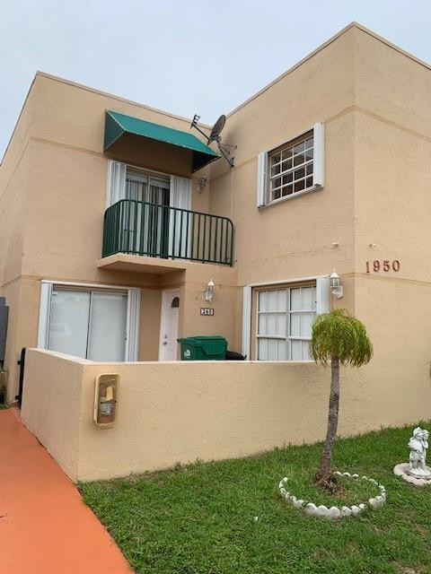 1950 Southwest 121st Court, Unit 240 Miami, FL 33175 - Photo 18 of 27 a front view of a house with yard and garage