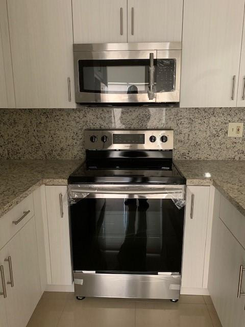 1950 Southwest 121st Court, Unit 240 Miami, FL 33175 - Photo 9 of 27 a stove top oven sitting inside of a kitchen
