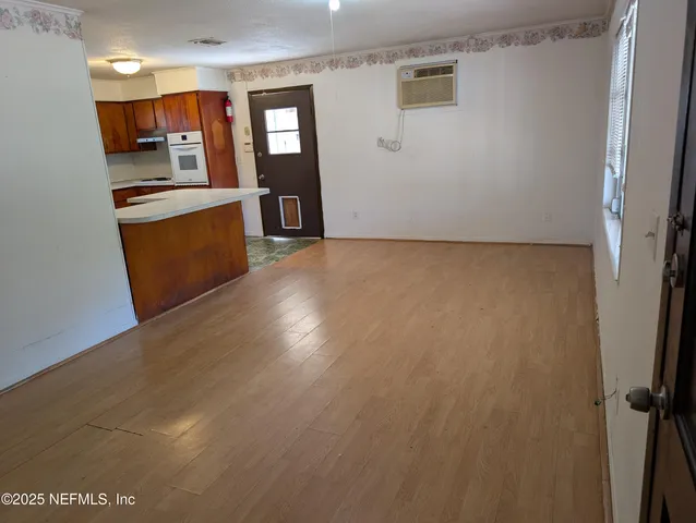 a view of a kitchen with wooden floor and electronic appliances
