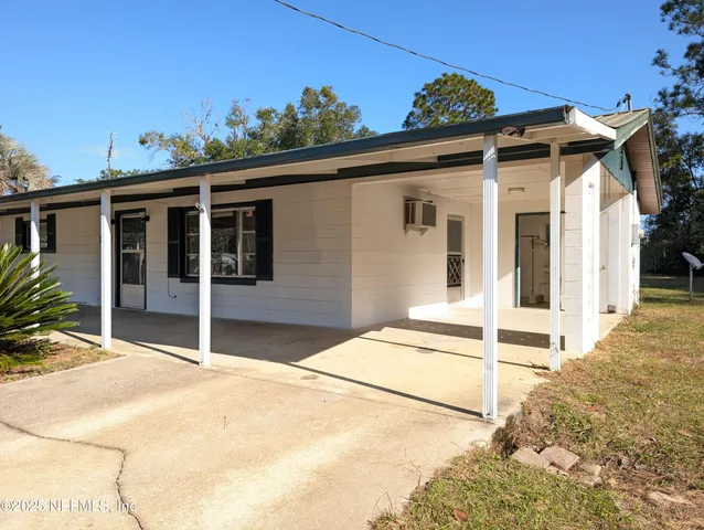 a front view of a house with a garden and plants