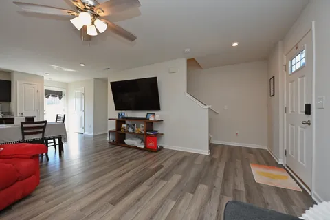 a view of a livingroom with furniture a flat screen tv and wooden floor