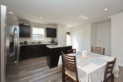a kitchen with a refrigerator and a stove top oven