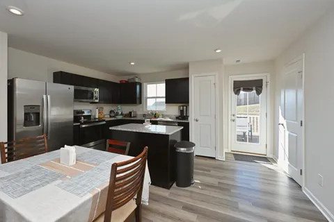 a kitchen with granite countertop stainless steel appliances a sink and refrigerator