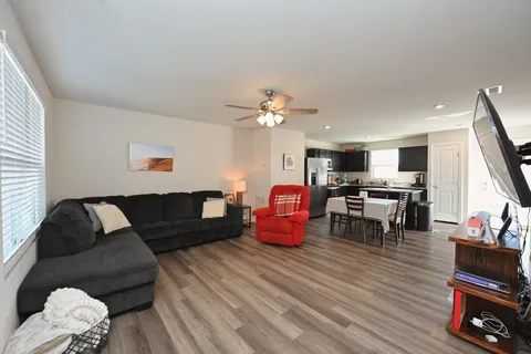 a living room with furniture and wooden floor