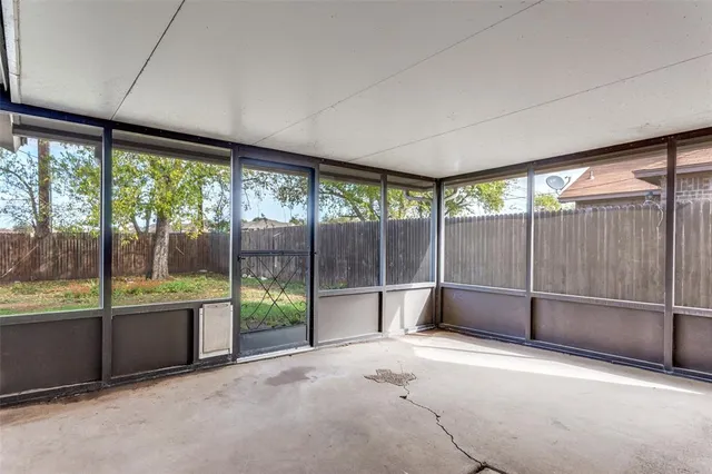 an empty room with sliding glass door and tree