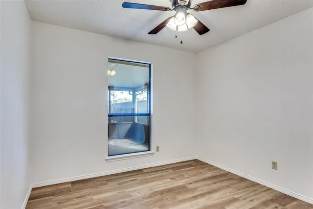 an empty room with fan and entrance