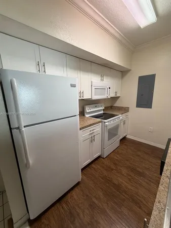 a kitchen with stainless steel appliances a refrigerator sink and wooden floor