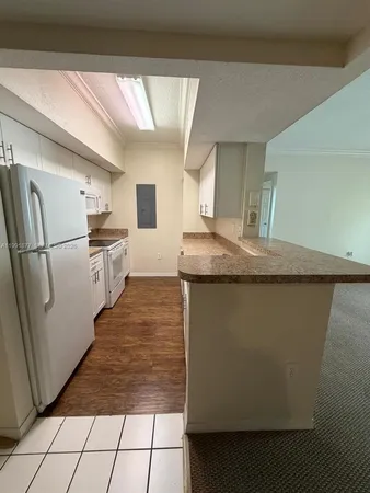 a kitchen with stainless steel appliances granite countertop a refrigerator a sink and a stove