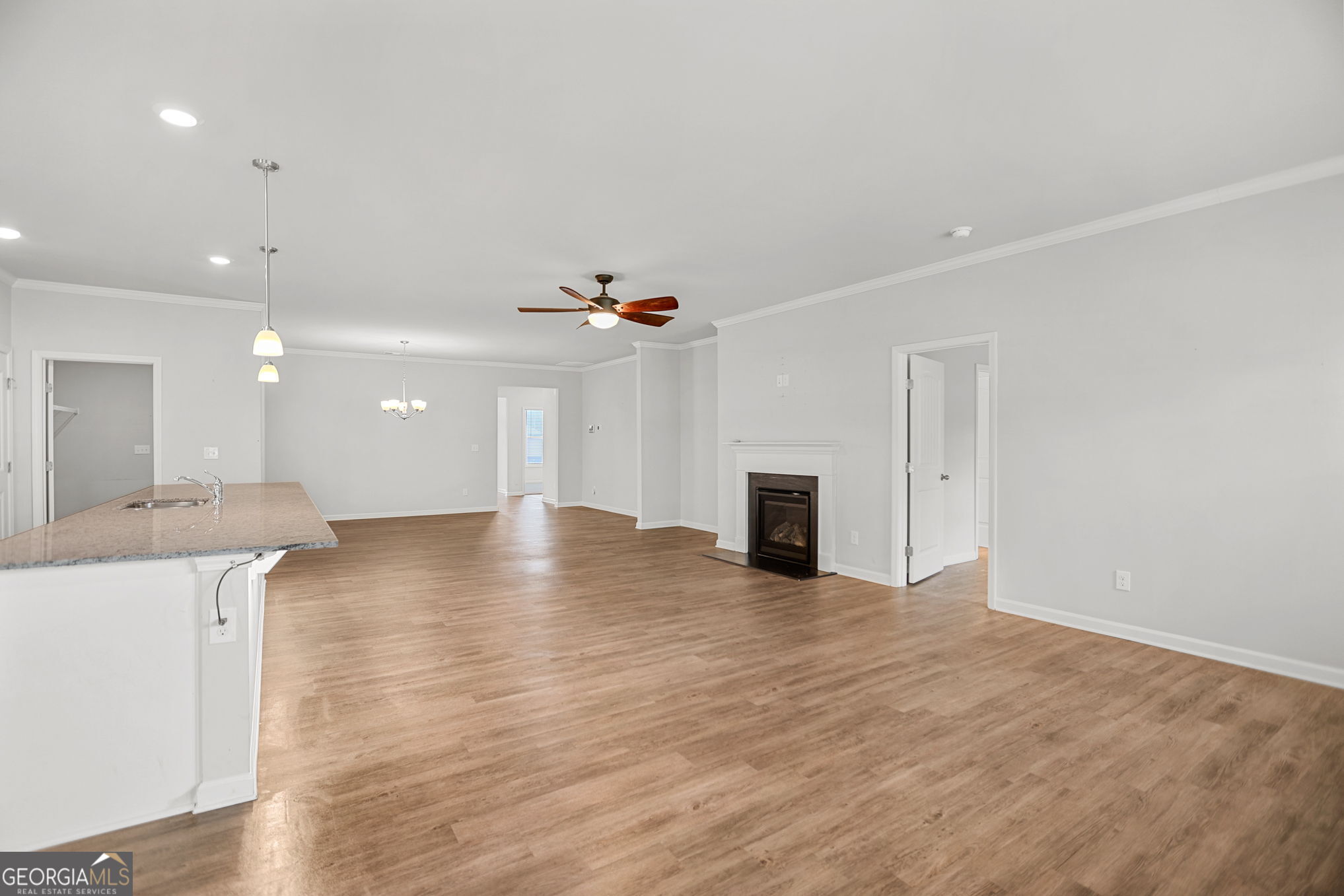 4605 Dandelion Way Cumming, GA 30040 - Photo 28 of 54 a view of an empty room with wooden floor and a kitchen