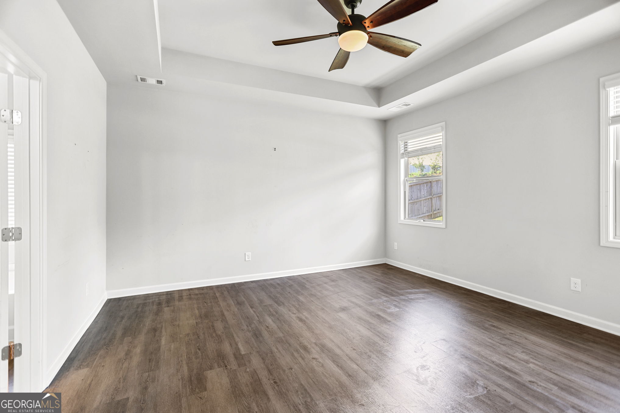 4605 Dandelion Way Cumming, GA 30040 - Photo 32 of 54 an empty room with wooden floor fan and windows