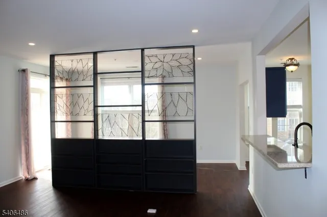 a view of a big room with wooden floor and windows
