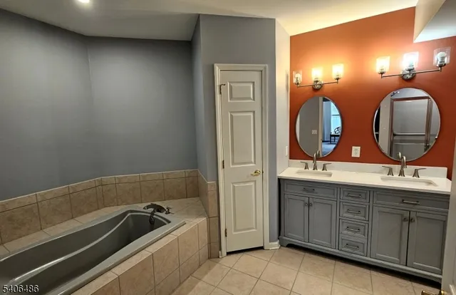 a bathroom with a tub sink and mirror