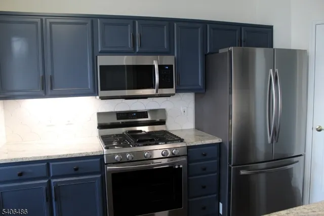 a kitchen with granite countertop stainless steel appliances and wooden cabinets