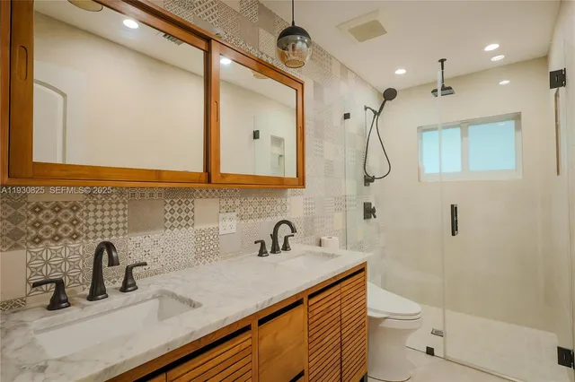 a bathroom with a sink a toilet and shower