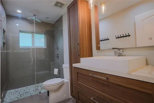 a bathroom with a sink a toilet and shower