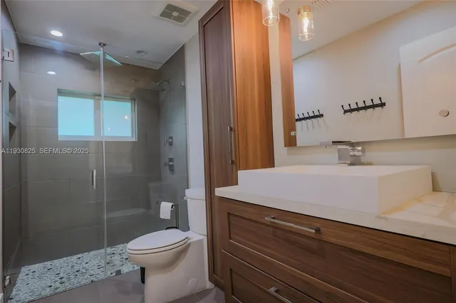 a bathroom with a sink a toilet and shower