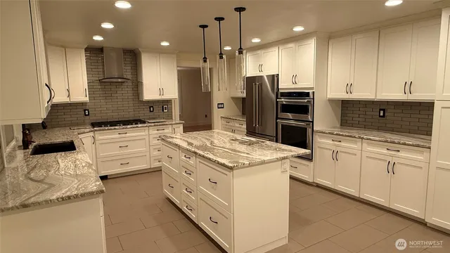 a kitchen that has a lot of cabinets in it and wooden floors