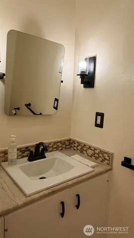 an empty room with wooden floor and mirror