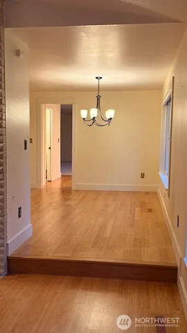 an empty room with wooden floor and a fireplace