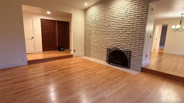 a view of an empty room with a chandelier fan