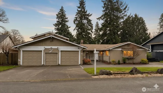 a view of a yard in front of a house with a large tree