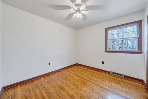 wooden floor in an empty room with a window