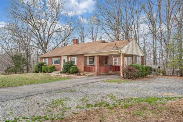 a view of a house with a yard and tree s