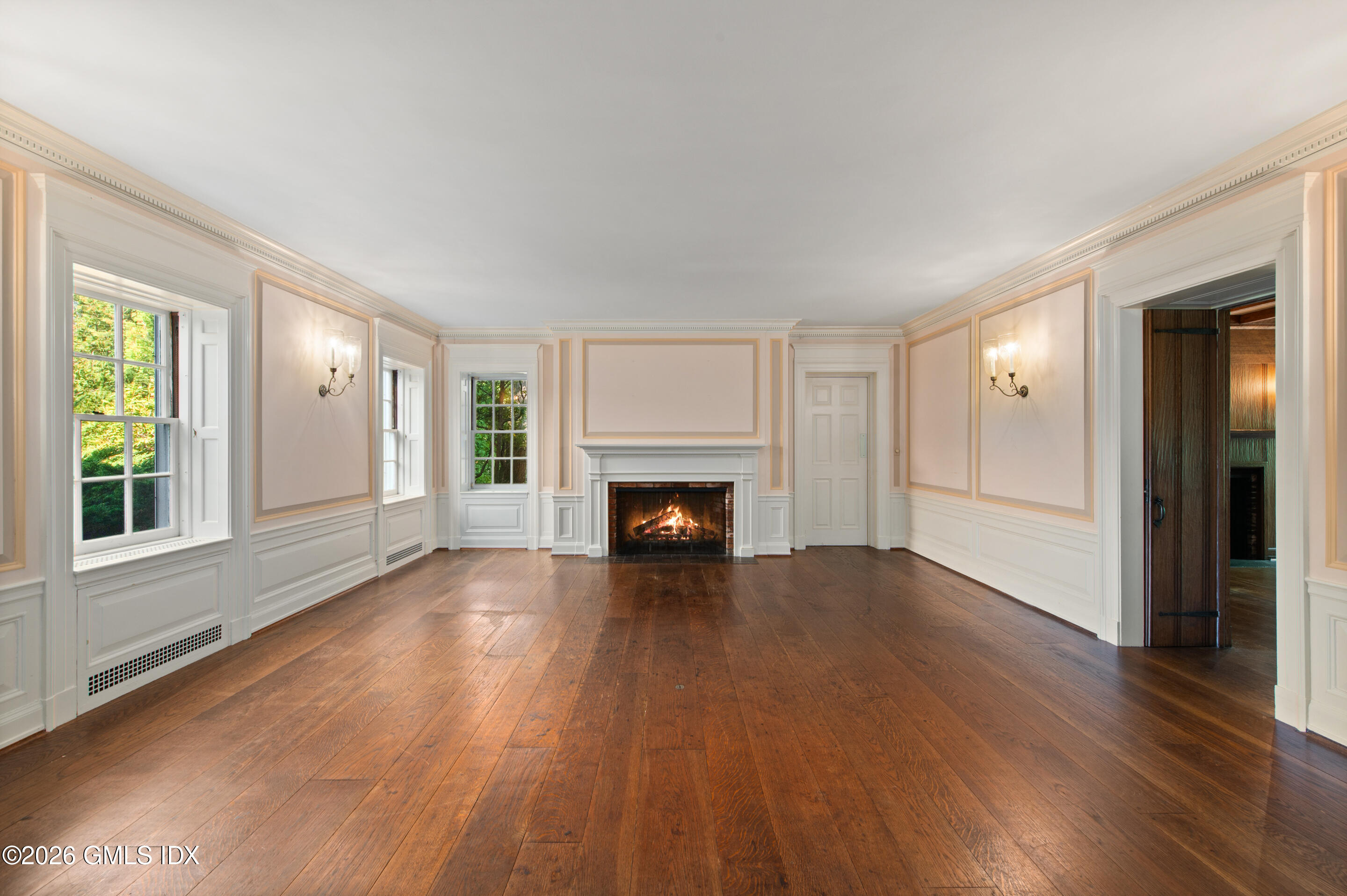 122 Round Hill Road Greenwich, CT 06831 - Photo 11 of 37 a view of an empty room with wooden floor windows and a fireplace