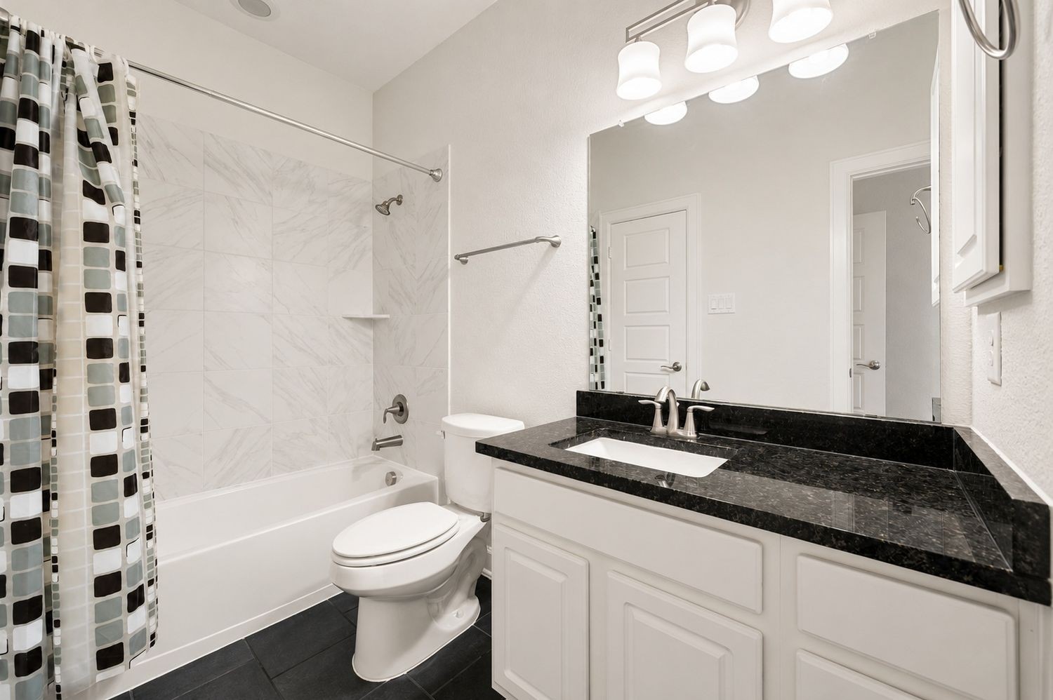 3622 Sage Hollow Drive Spring, TX 77386 - Photo 30 of 46 The secondary upstairs bathroom features a white vanity cabinet with a dark granite countertop and a clean tub and shower combination with custom tile surrounds.