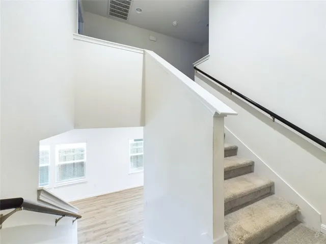 a view of staircase with white walls and a window
