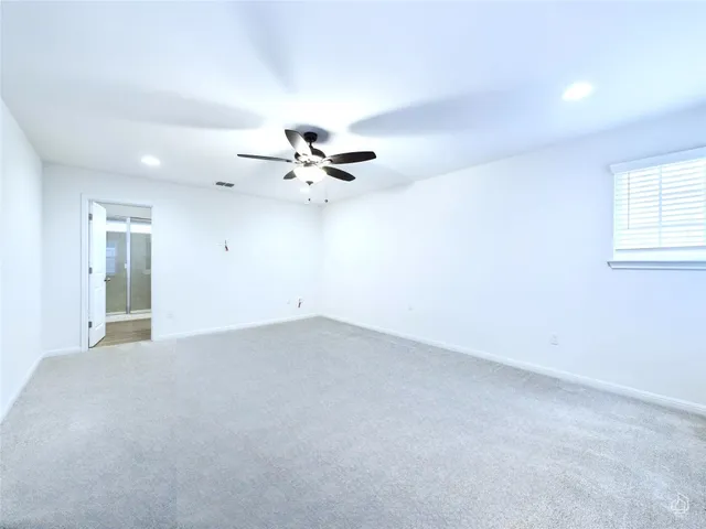 a view of an empty room with a chandelier fan