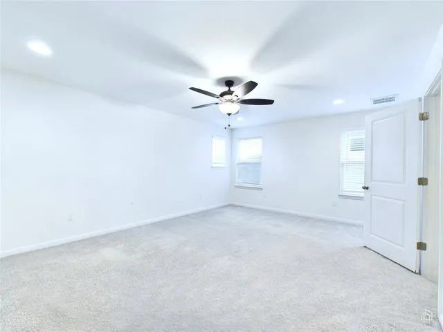 an empty room with fan and windows