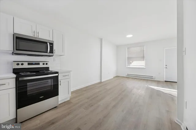 a view of kitchen with microwave stove and cabinets