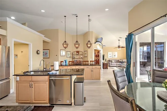 a large kitchen with kitchen island granite countertop a large counter top appliances and a view of living room