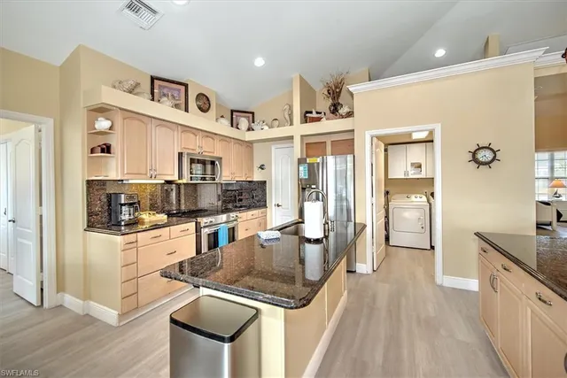 a kitchen with stainless steel appliances granite countertop a refrigerator and a stove top oven