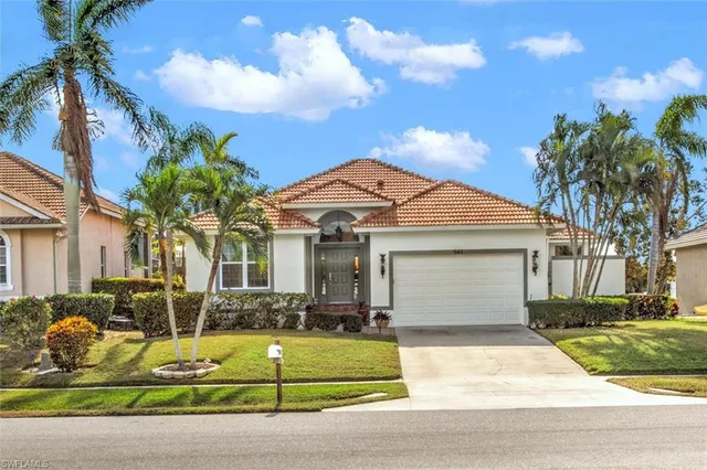 a view of a white house with a yard and potted plants