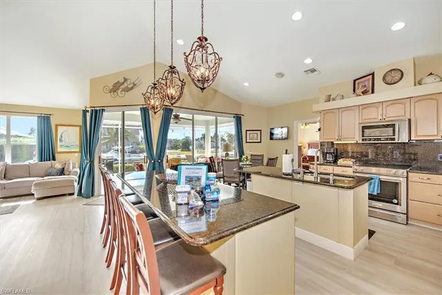 a view of a dining room and livingroom with furniture wooden floor a chandelier