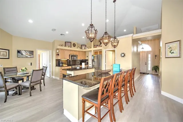 a view of a dining room and livingroom with furniture wooden floor a chandelier