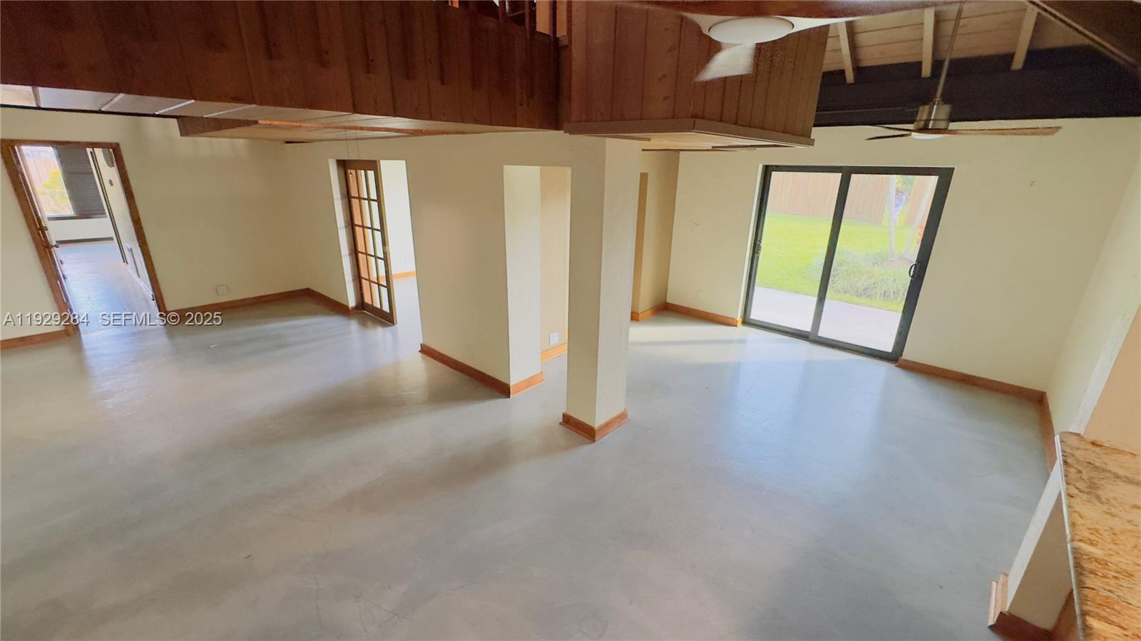 18350 Southwest 214th Street Miami, FL 33187 - Photo 17 of 24 a view of an empty room with wooden floor and a window