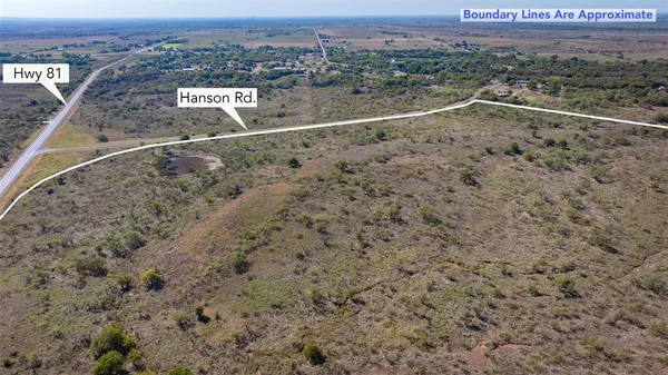 a view of a dry field with mountains in the background