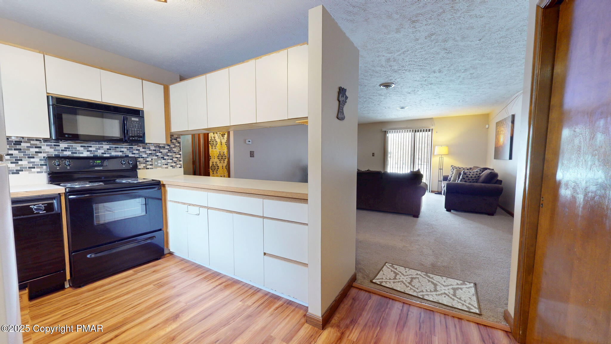 130 Foxfire Drive, Unit 103 Mount Pocono, PA 18344 - Photo 13 of 38 a kitchen with stainless steel appliances kitchen island granite countertop a stove a sink dishwasher and a refrigerator with wooden floor