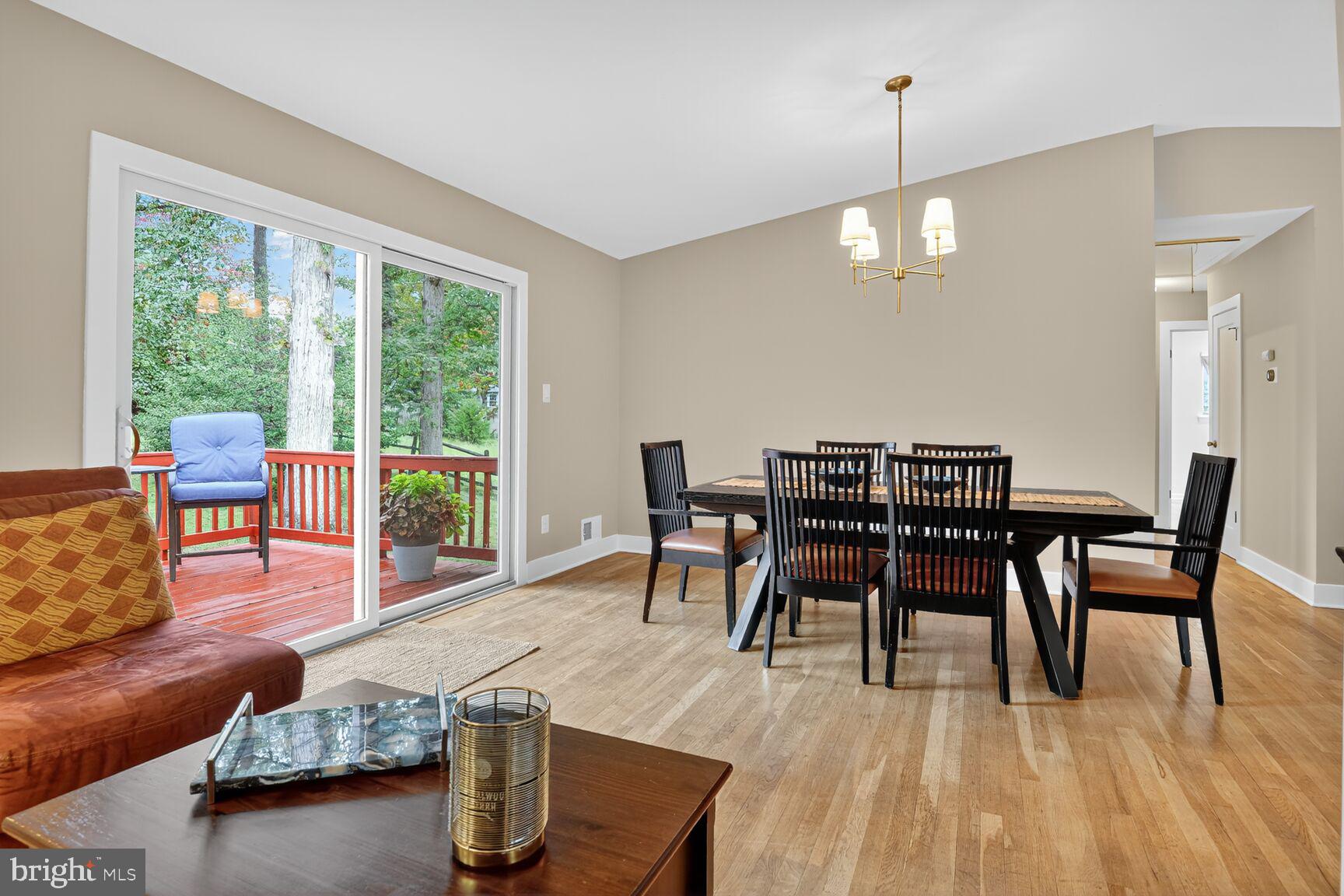 4618 Twinbrook Road Fairfax, VA 22032 - Photo 3 of 24 a dining room with wooden floor a chandelier a glass table and chairs