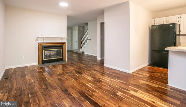 a view of empty room with wooden floor and fireplace