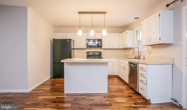 a kitchen with a refrigerator sink and cabinets
