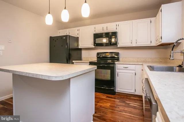 a kitchen with stainless steel appliances granite countertop a sink a stove a microwave and cabinets