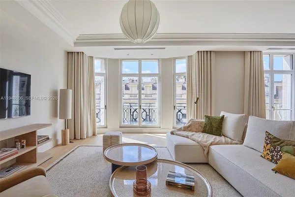 a living room with furniture a fireplace and a chandelier