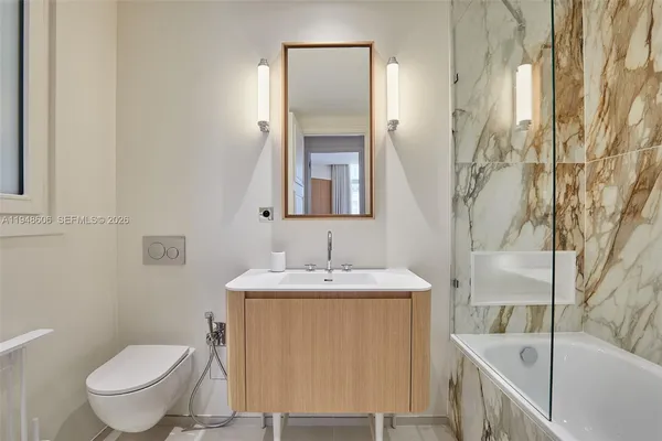 a bathroom with a granite countertop sink toilet and mirror