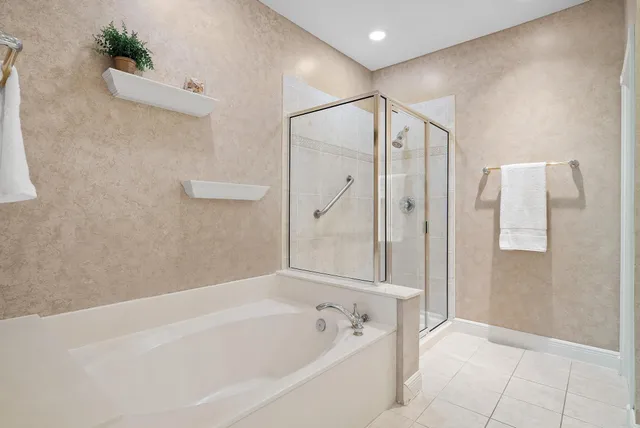 a spacious bathroom with a shower a sink and a mirror