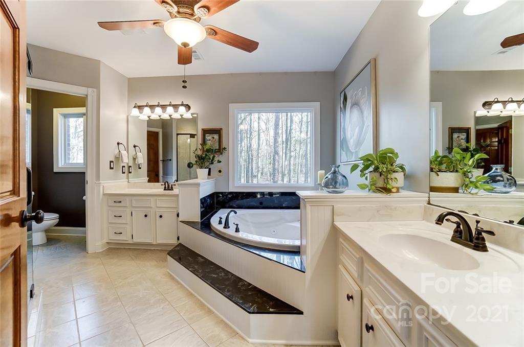 1517 Helms Shortcut Road Monroe, NC 28112 - Photo 16 of 45 a bathroom with a sink a faucet a chandelier and bathtub
