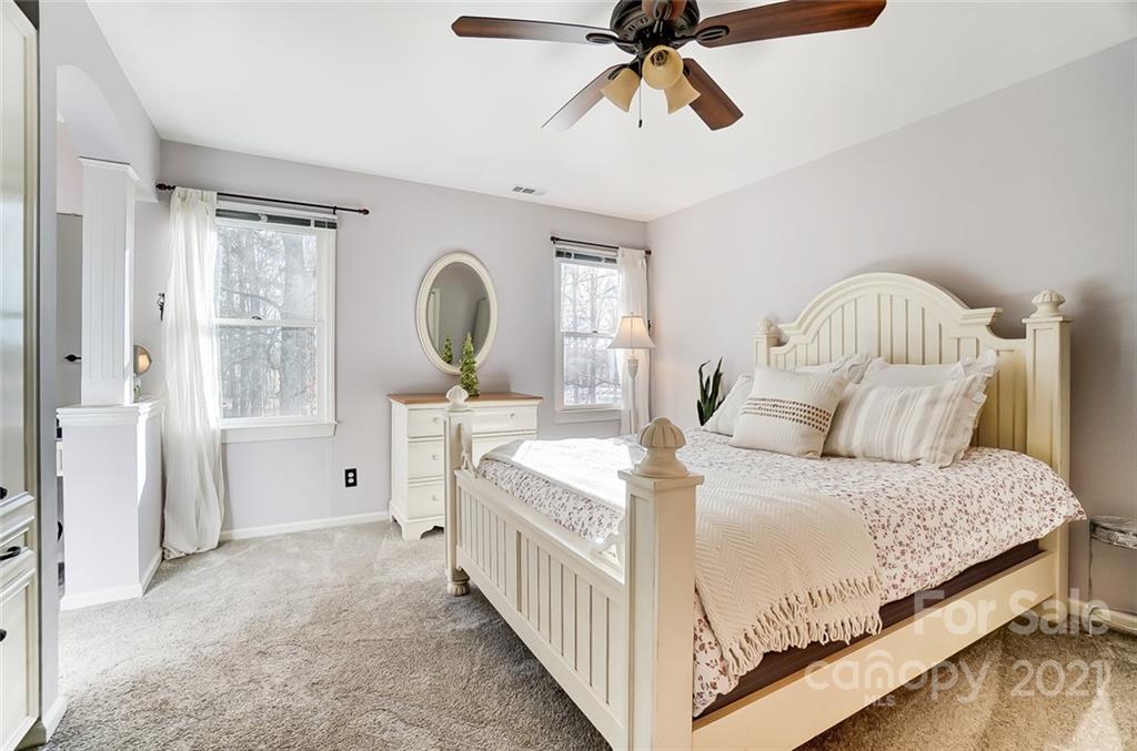 1517 Helms Shortcut Road Monroe, NC 28112 - Photo 26 of 45 a bedroom with a bed a mirror on the dresser and a chandelier